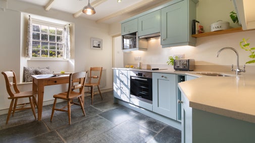 The kitchen with a table for three at Quin Cottage, Cornwall
